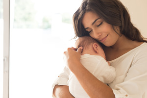 Woman holding her baby close