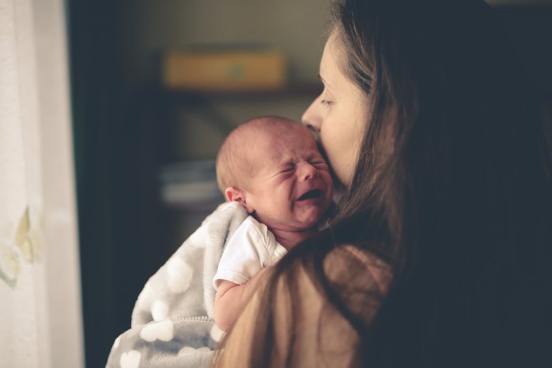 a mother holding a crying infant